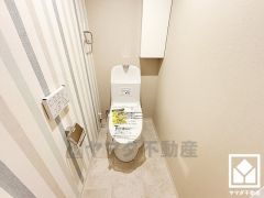 明るく清潔感溢れるトイレです。温水洗浄便座付きで、トイレットペーパーのストックや消耗品置き場などとしてお使いいただける吊戸棚がございます。