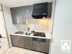 キッチンは空間を有効活用できる壁付けタイプ。換気効率が高いブーツ型のレンジフードを採用。