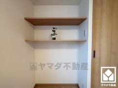 約5.4帖の洋室の壁面には棚が設置されており、飾り棚や書棚、収納などとしてもお使いいただけます。