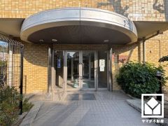 緑に囲まれたエントランスが、都会の喧騒を忘れさせる。自然と調和する、美しい迎賓空間。