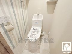 明るく清潔感溢れるトイレです。トイレットペーパーのストックや消耗品置き場、小物置きなどとしてもお使いいただける棚がございます。