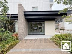 緑に囲まれたエントランスが、都会の喧騒を忘れさせる。自然と調和する、美しい迎賓空間。