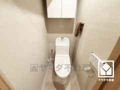 明るく清潔感溢れるトイレです。トイレットペーパーのストックや消耗品置き場などとしてお使いいただける吊戸棚がございます。
