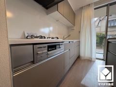 キッチンは空間を有効活用できる壁付けタイプ。背面には下部収納付きのカウンターもあり、スッキリとした空間が保てます。