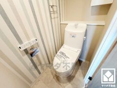 明るく清潔感溢れるトイレです。タオル掛けやペーパーホルダーが設置されています。