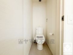 明るく清潔感溢れるトイレです。タオル掛けやペーパーホルダーが設置されています。