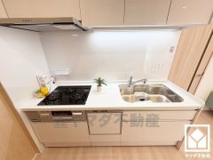 壁付けタイプで空間を有効活用。明るい白色で統一された清潔感のあるデザインが魅力のシステムキッチンです。統一されたデザインの家電収納付カップボードもございます。