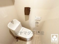 明るく清潔感溢れるトイレです。トイレットペーパーのストックや消耗品置き場などとしてお使いいただける吊戸棚がございます。