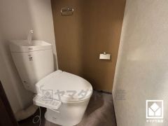 明るく清潔感溢れるトイレです。タオル掛けやペーパーホルダーが設置されています。