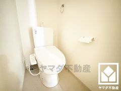 明るく清潔感溢れるトイレです。タオル掛けやペーパーホルダーが設置されています。