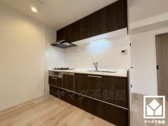 使いやすさとデザイン性を両立。落ち着いた木目調のデザインが魅力のシステムキッチンです。空間を有効活用できる壁付けタイプ。