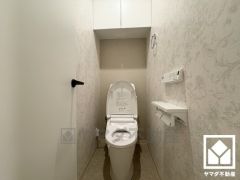 明るく清潔感溢れるトイレです。トイレットペーパーのストックや、消耗品置き場などとしてお使いいただける吊戸棚がございます。