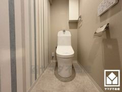 明るく清潔感溢れるトイレです。トイレットペーパーのストックや消耗品置き場などとしてお使いいただける吊戸棚がございます。