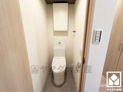明るく清潔感溢れるトイレです。タオル掛けやペーパーホルダーが設置されています。