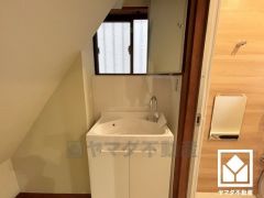 窓から柔らかな光が差し込む明るい洗面台です。吊戸棚も設置されており、スッキリお使い頂けます。