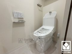 明るく清潔感溢れるトイレです。トイレットペーパーのストックや消耗品置き場などとしてお使いいただける吊戸棚がございます。