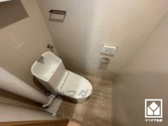 明るく清潔感溢れるトイレです。トイレットペーパーのストックや、消耗品置き場などとしてお使いいただける吊戸棚がございます。