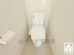 明るく清潔感溢れるトイレです。ペーパーホルダーが設置されています。