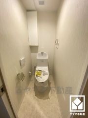 明るく清潔感溢れるトイレです。トイレットペーパーのストックや、消耗品置き場などとしてお使いいただける吊戸棚がございます。