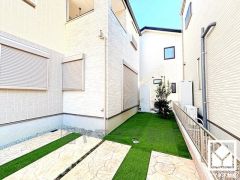 駐車スペースを普通車並列2台分確保。重い荷物や雨の日の移動もスムーズで、快適なカーライフを実現。来客時にも便利です。奥はガーデニングやお子様のプール・遊び場にもなる人工芝付きのお庭になっています。