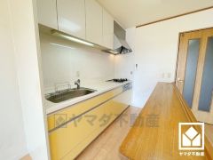 キッチンは空間を有効活用できる壁付けタイプ。背面にはカウンター付きのキャビネットがございますので配膳や片付けがしやすくなり、スッキリとした空間が保てます。