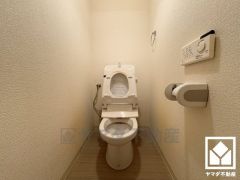 明るく清潔感溢れるトイレです。タオル掛けやペーパーホルダーが設置されています。