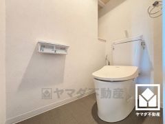 明るく清潔感溢れるトイレです。2連トイレットペーパーホルダーなのでお取替えの手間が軽減できます。トイレットペーパーのストックや、消耗品置き場、小物置きなどとしてもお使いいただける棚がございます。