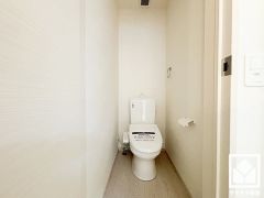 明るく清潔感溢れるトイレです。タオル掛けやペーパーホルダーが設置されています。