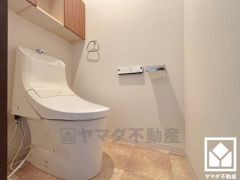 明るく清潔感溢れるトイレです。トイレットペーパーのストックや、消耗品置き場、小物置きなどとしてもお使いいただける吊戸棚がございます。