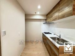 キッチンは空間を有効活用できる壁付けタイプ。使いやすさとデザイン性を両立。落ち着いた木目調のデザインが魅力のシステムキッチンです。