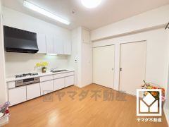キッチンは空間を有効活用できる壁付けタイプ。同時調理ができる、便利な3口コンロ付き。
