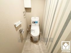 明るく清潔感溢れるトイレです。タオル掛けやペーパーホルダーが設置されています。