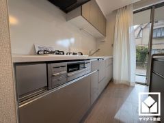 キッチンは空間を有効活用できる壁付けタイプ。背面には下部収納付きのカウンターもあり、スッキリとした空間が保てます。