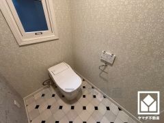上品な壁紙と遊び心のあるタイルデザインが魅力的なトイレ空間。機能性とセンスが融合した、居心地の良いプライベートスペースです。