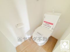明るく清潔感溢れるトイレです。タオル掛けやペーパーホルダーが設置されています。