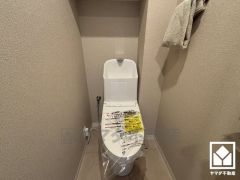 明るく清潔感溢れるトイレです。トイレットペーパーのストックや消耗品置き場などとしてお使いいただける吊戸棚がございます。
