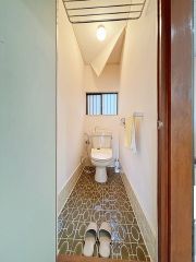 明るく清潔感溢れるトイレです。タオル掛けやペーパーホルダーが設置されています。