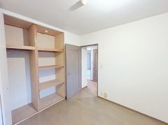 壁面を有効活用したオープンクローゼットのある洋室。棚も多く、整理整頓しやすい設計です。