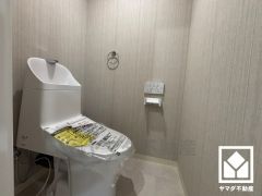 明るく清潔感溢れるトイレです。タオル掛けやペーパーホルダーが設置されています。