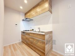 キッチンは空間を有効活用できる壁付けタイプ。使いやすさとデザイン性を両立。落ち着いた木目調のデザインが魅力のシステムキッチンです。