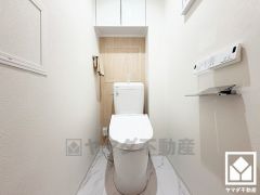 明るく清潔感溢れるトイレです。トイレットペーパーのストックや消耗品置き場などとしてお使いいただける吊戸棚がございます。
