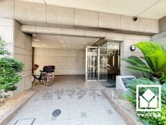 緑に囲まれたエントランスが、都会の喧騒を忘れさせる。自然と調和する、美しい迎賓空間。