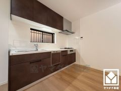 キッチンは空間を有効活用できる壁付けタイプ。フロアキャビネットや吊戸棚など収納スペースが充実しており、スッキリお使いいただけます。