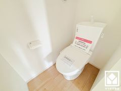 明るく清潔感溢れるトイレです。タオル掛けやペーパーホルダーが設置されています。