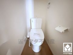 明るく清潔感溢れるトイレです。タオル掛けやペーパーホルダーが設置されています。