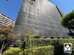 陽光に映える美しい外観。街並みに馴染みながらも、ひときわ目を引く存在感。現在大規模修繕工事中です。