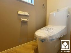 明るく清潔感溢れるトイレです。タオル掛けやペーパーホルダーが設置されています。