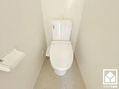 明るく清潔感溢れるトイレです。ペーパーホルダーが設置されています。